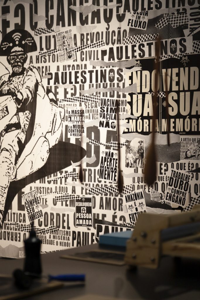 O coletivo Paulestinos (SP) apresenta uma colagem em grande formato, composta por lambe-lambes poéticos e imagens que fundem referências do cangaço e dos mangás, unindo a construção de imagens digitais com a poesia visual contemporânea. Foto: Adriana Vichi.