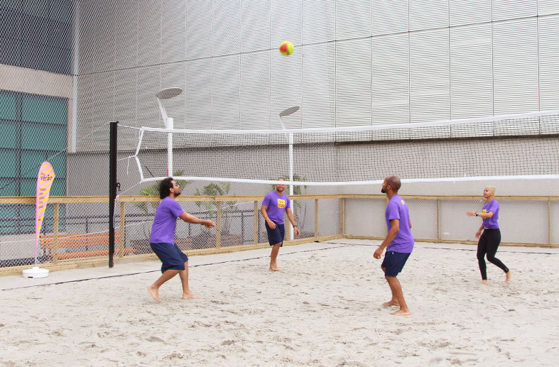Quadra de areia no Sesc Santo Amaro com quatro educadores jogando vôlei