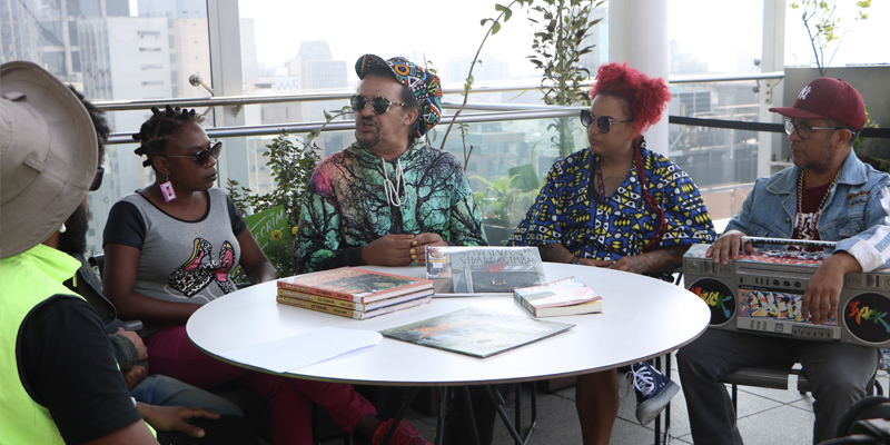 Nelson Triunfo, no centro da imagem, conversa com os personagens da websérie Olhares Sobre São Paulo - Especial Hip-Hop Foto Carol Balza