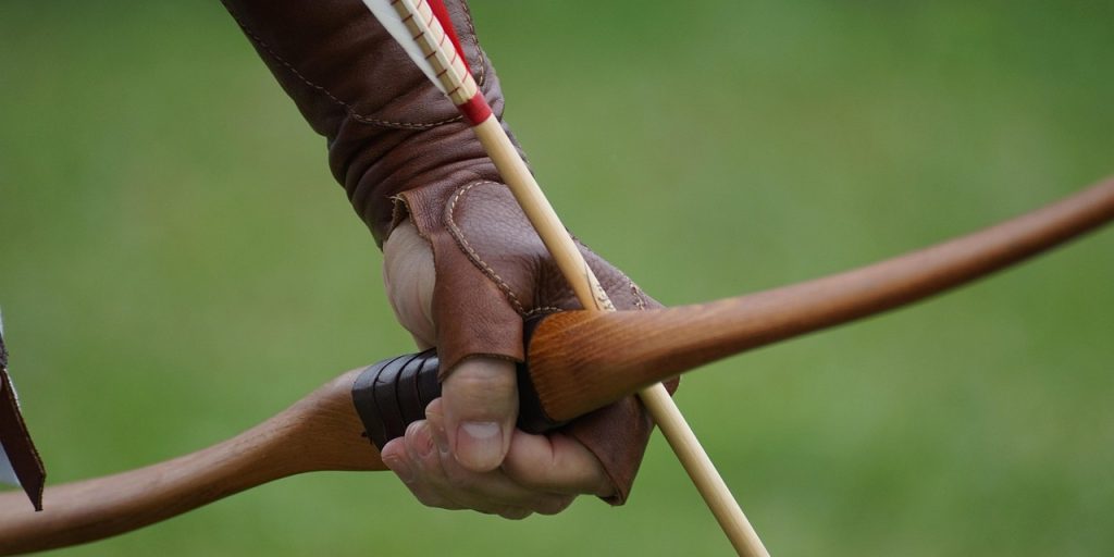 mão segurando arco e flecha