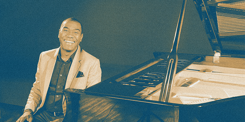 Hércules Gomes sentado ao piano