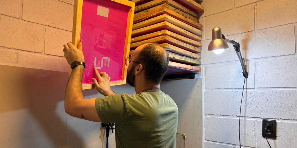 Homem segurando tela de serigrafia