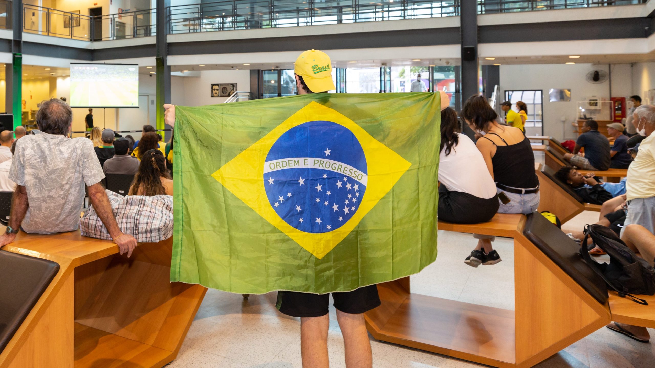 HOmem segurando uma bandeira do Brasil